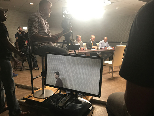 The Insurance Apprentice judges Gareth Joubert, Simon Colman and Marvin Tshezi (all seated) wait to brief the contestants in front of a video-camera